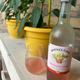 Bottle of Boone's Farm next to glass full of pink liquid